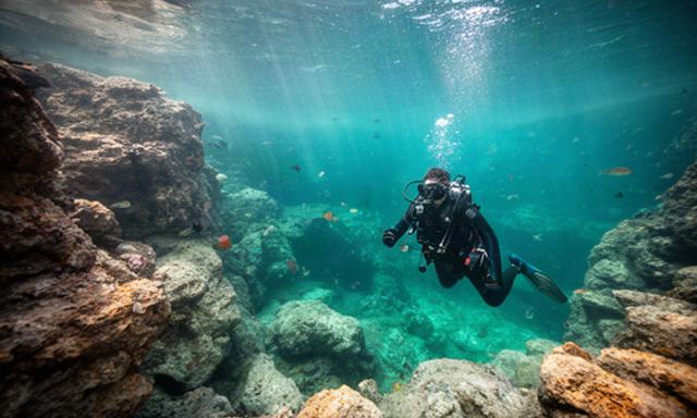Buceador explorando una cala de la Costa Brava con aguas transparentes