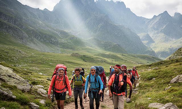 Senderistas avanzando por un sendero de montaña en los Pirineos