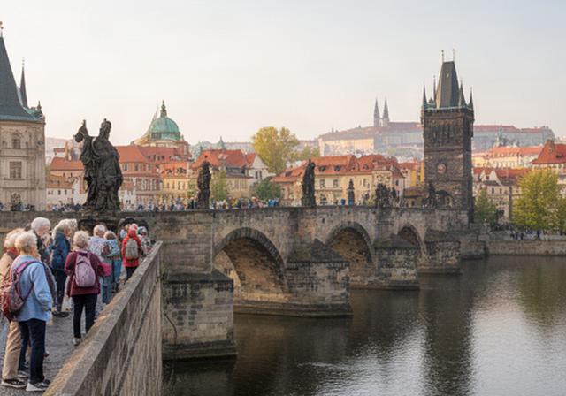 Puente histórico de Praga visto por viajeros sénior durante una visita cultural